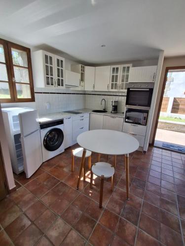 une cuisine avec des armoires blanches et une table avec des chaises dans l'établissement La belle des trappes 2, à Saint-Agnin-sur-Bion