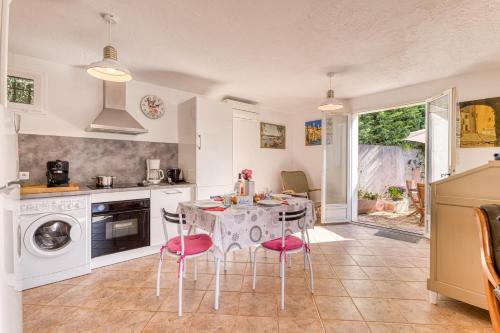 une cuisine avec une table et des chaises roses dans l'établissement Maison Baousset - Happy Rentals, à Menton