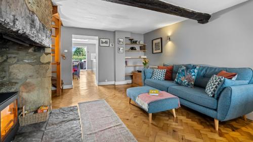 un soggiorno con un divano blu e un camino di Horsefair Cottage a Malmesbury