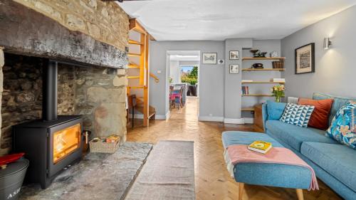un soggiorno con un divano blu e un camino di Horsefair Cottage a Malmesbury