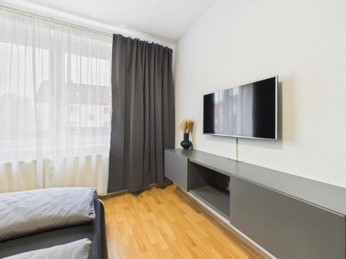 a living room with a flat screen tv on a wall at Loft & Living 2 am Geiseltalsee WLAN Netflix Parkplatz in Braunsbedra