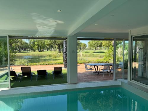 une maison avec une piscine, une table et des chaises dans l'établissement Logement de Prestige avec piscine Vue sur le Golf de la Grande Motte, à La Grande Motte