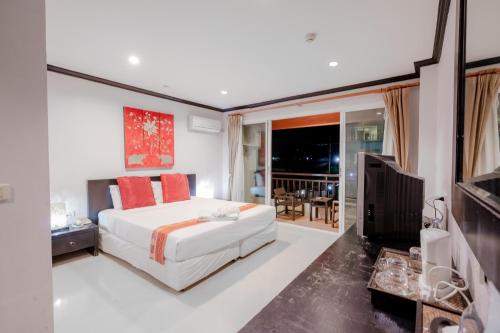 une chambre avec un lit blanc et une télévision dans l'établissement Napalai Resort Hua Hin, à Hua Hin