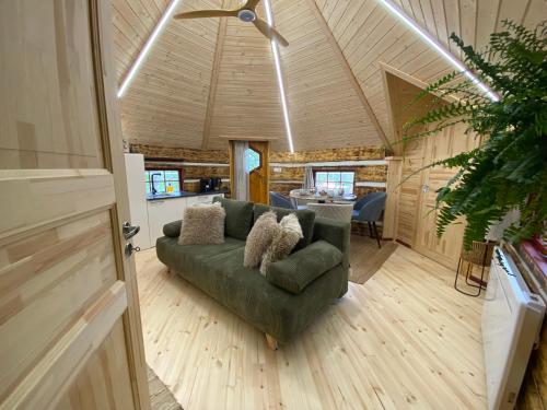 una sala de estar con un sofá verde en una casa en Le Féérik, en Foncine-le-Haut