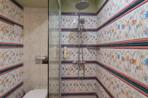 a bathroom with a shower with colorful tiles at Hotel Casa Art in Oreshak