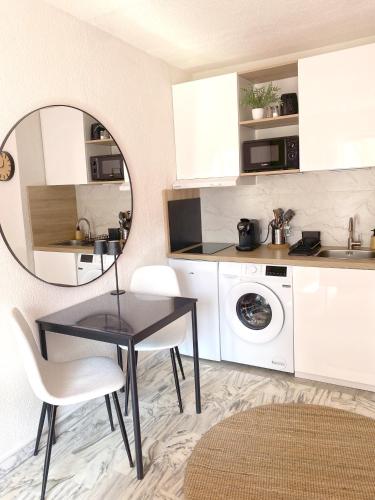 - une petite cuisine avec une table et un miroir dans l'établissement A deux pas des plages et au coeur du vieil Antibes , beau studio rénové, à Antibes