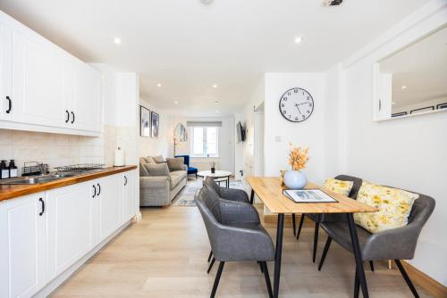 a kitchen and living room with a table and chairs at Stylish 2BR Home Near Canary Wharf with Garden & Free Parking in London