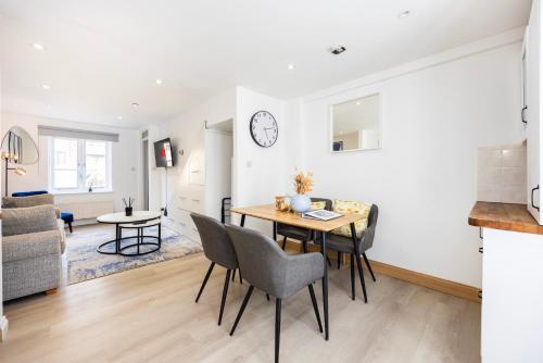 a kitchen and living room with a table and chairs at Stylish 2BR Home Near Canary Wharf with Garden & Free Parking in London