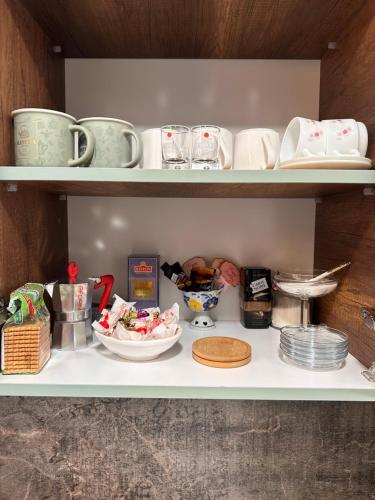 a shelf with dishes and cups and plates on it at Casa de Sogno in Tbilisi City