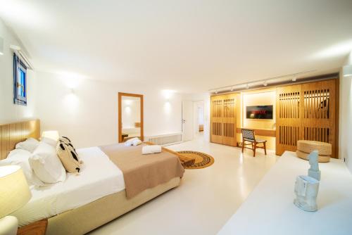 a bedroom with a large bed and a living room at Villa Ohana Paros in Chrissi Akti