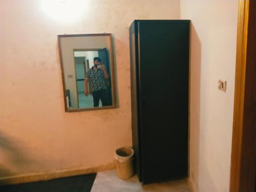 a man taking a picture of himself in a mirror at Grand Arham Hotel in Dargai