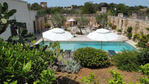 widok na basen z parasolami w obiekcie Masseria Bernardini by Symphonya Luxury Rentals w mieście Nardò