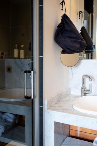 a bathroom with a sink and a purse hanging on the wall at Les chambres du Waterzooi in Dunkerque