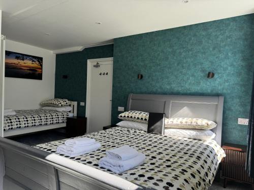 two beds in a room with green walls at St Georges Guest House in St Peter Port