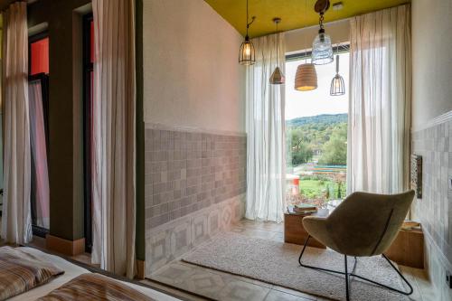 a bedroom with a bed and a chair and a window at Hotel Casa Art in Oreshak