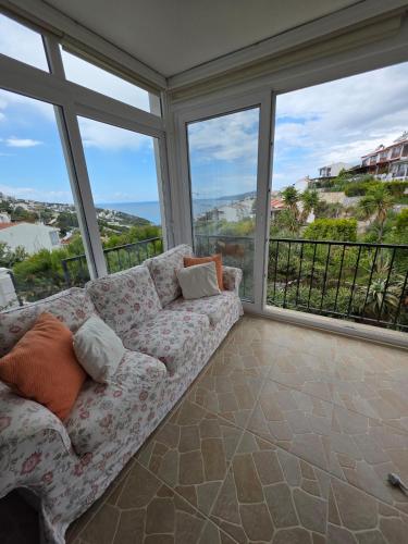 a living room with a couch and large windows at Sevinc Akasya Luxury Villa in Milas
