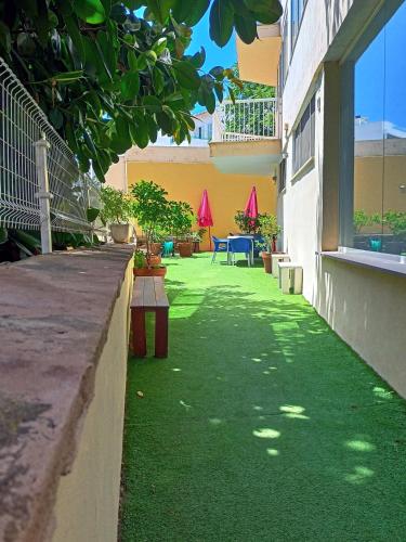 a courtyard of a building with green grass at Palma Port Hostel - Albergue Juvenil in Palma de Mallorca