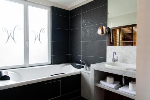 a bathroom with a white tub and a sink at Les chambres du Waterzooi in Dunkerque