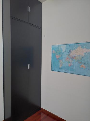 a black cabinet next to a wall with a map at Duplex la plaza in Hoznayo