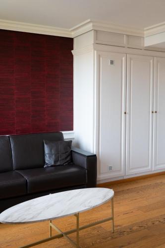 a living room with a black couch and a coffee table at Les chambres du Waterzooi in Dunkerque