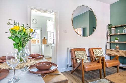 Un comedor con una mesa y sillas y un espejo. en Little Domus - With Hot Tub, en York