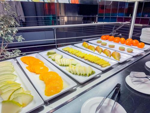 a buffet line with different types of food on trays at Hotel Jardines de Uleta Suites in Vitoria-Gasteiz