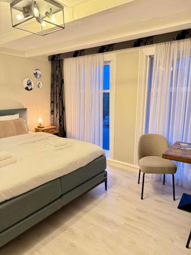 a bedroom with a bed and a desk and a chair at De Stadshoeve in Medemblik