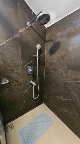 a shower with a shower head in a bathroom at Aura Farms - Private Pool Cottages in Rāmanagaram