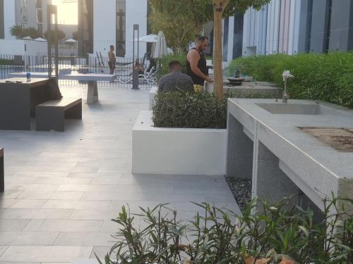 a man sitting at a table in a courtyard at Snazzy Studio, Cozy & Exquisite in Sharjah