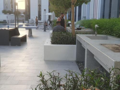a woman standing in a courtyard with tables and benches at Snazzy Studio, Cozy & Exquisite in Sharjah