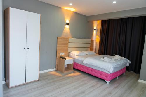 a small bedroom with a bed and a night stand at Rio's Hotel AİRPORT in Istanbul