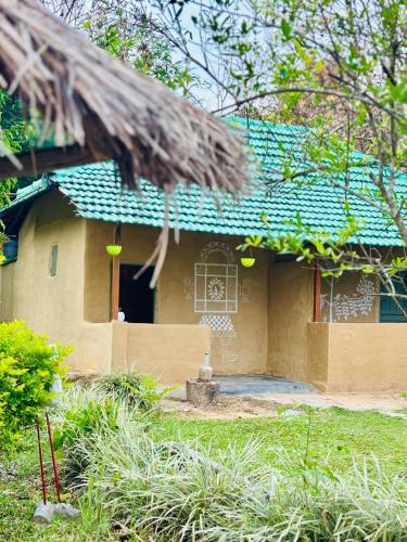 a house with a green roof and a yard at Cure Monastery Family Resort in Marayoor