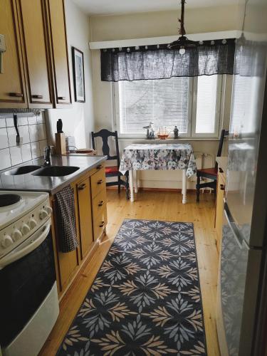 a kitchen with a table and a kitchen rug at Yyterin portti in Pori