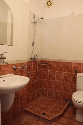 a bathroom with a shower and a toilet and a sink at Апартаменти Амфора in Pomorie