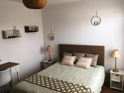 - une chambre avec un lit avec deux lampes et deux tables dans l'établissement Les Sables superbe T3 cadre unique 7mn à pied de la mer, à Les Sables-dʼOlonne
