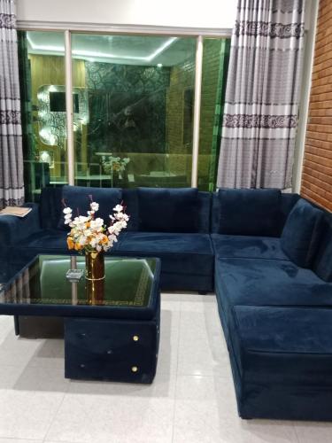 a living room with a blue couch and a table at Green view guest house nathiagali by room in Nathia Gali