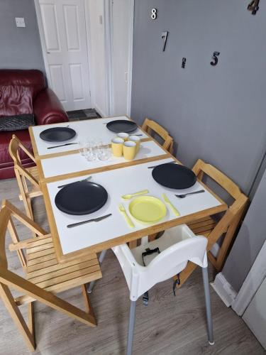a table with chairs and a table with plates on it at Canny Hyem in Birtley