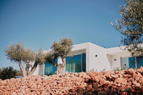 a white house with trees in front of it at Quinta dos Vales Wine Estate in Estômbar