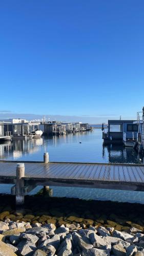 a dock with a house and boats on the water at Loft & Living 2 am Geiseltalsee WLAN Netflix Parkplatz in Braunsbedra