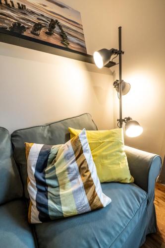 a blue couch with a yellow pillow on it at 4 - saniertes Apartment im Dankmalschutz - nur kurze Zeit verfügbar in Brunsbüttel