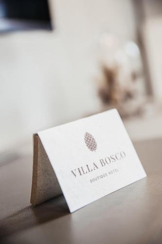 a white card sitting on top of a table at Villa Bosco - Boutiquehotel in Walldorf