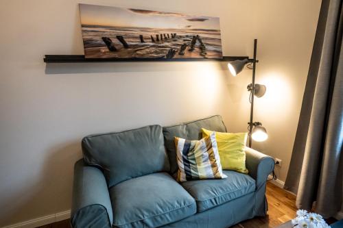 a blue couch in a living room with a painting on the wall at 4 - saniertes Apartment im Dankmalschutz - nur kurze Zeit verfügbar in Brunsbüttel