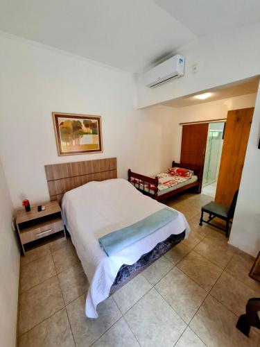 a bedroom with a bed and a chair in it at Vila Palmar Hospedagem in Vassouras