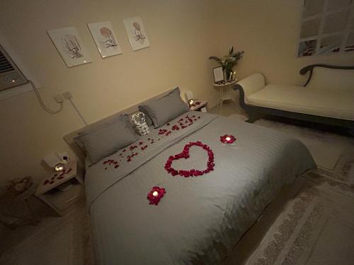 a bedroom with a bed with red flowers on it at HOMEY iNN in Al Madinah