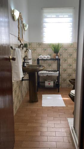a bathroom with a sink and a counter with a window at Casa Vista Mar in Porto Martins