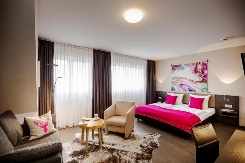 a hotel room with a bed and a chair at Altstadt-Hotel Bielefeld in Bielefeld