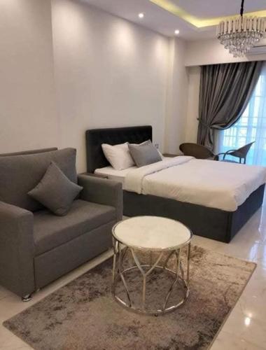 a bedroom with a bed and a couch and a table at كمبوند سكاي 2 in Hurghada