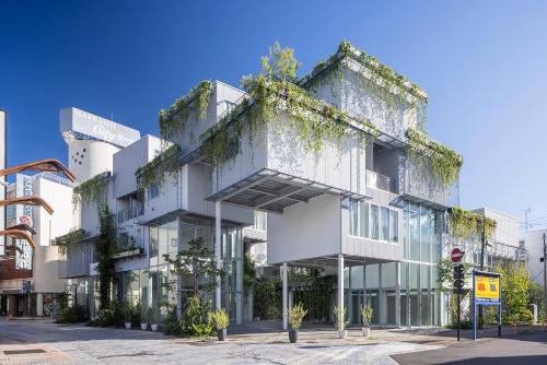 an apartment building with ivy on the side of it at まえばしガレリアArt residence & Hotel in Maebashi