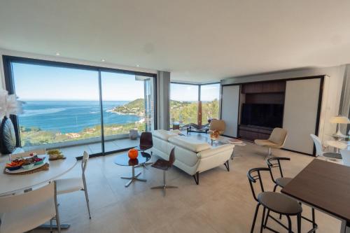 un salon avec un canapé, une table et des chaises dans l'établissement Maredo - West Corsica Stunning view, Infinity pool, à Tiuccia