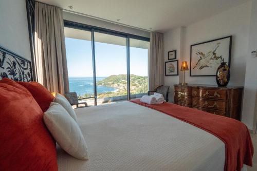 une chambre avec un grand lit et une grande fenêtre dans l'établissement Maredo - West Corsica Stunning view, Infinity pool, à Tiuccia